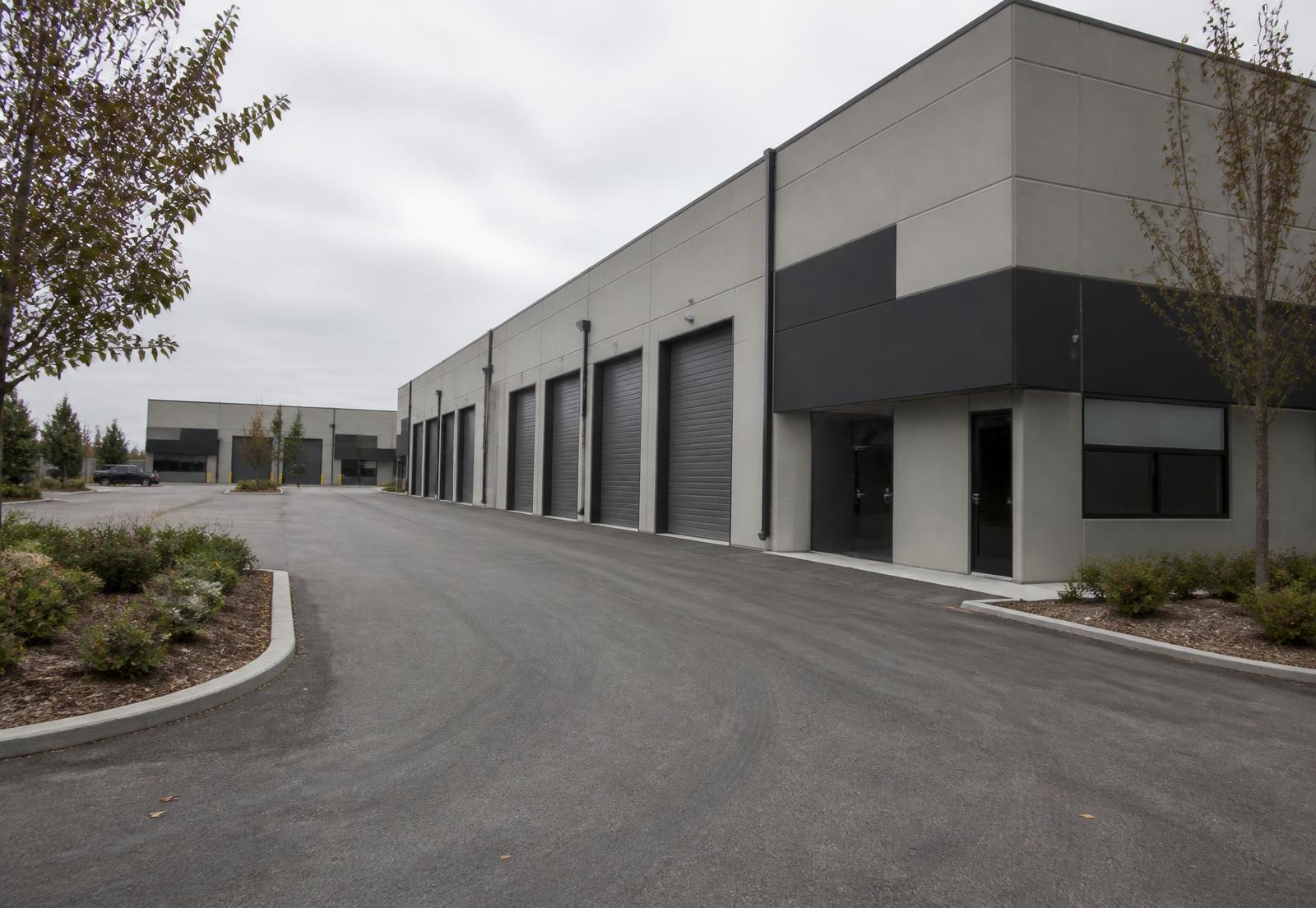 Placeholder photo of a multi-unit light industrial building and its driveway approach, to be replaced with the actual Ford Drive entrance